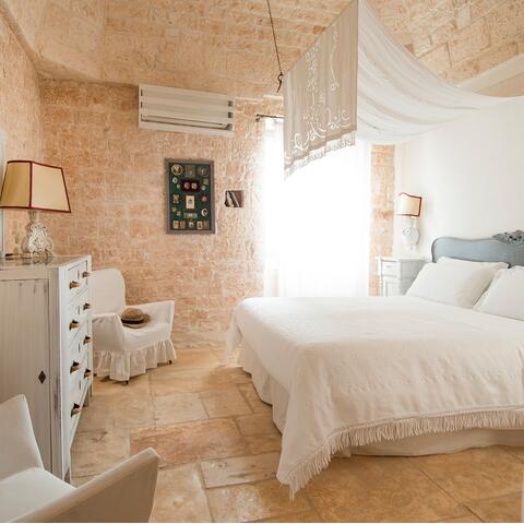 A stone-walled bedroom at Masseria Salinola