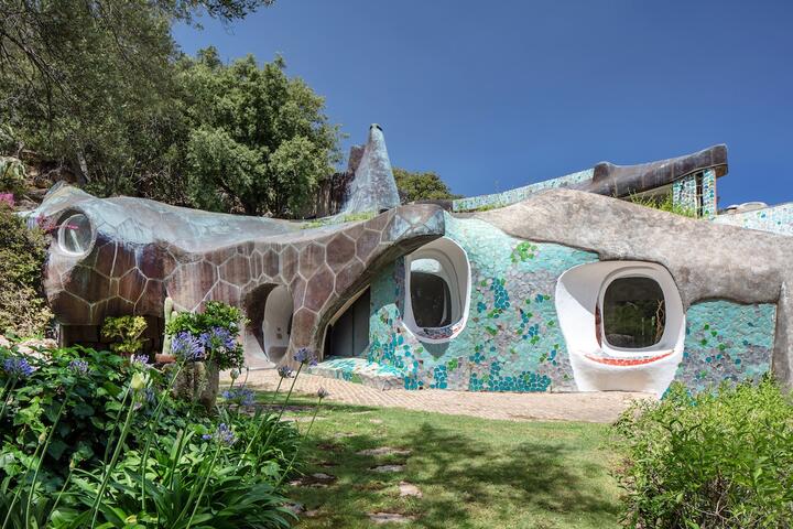 The façade of Jacques Couëlle’s organically shaped structure is embellished with a blue- green mosaic, mirroring the colors of the bay.