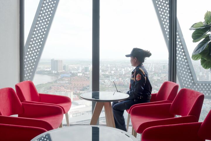 A security guard is looking out the window from the last floor of The Bridge, a high-rise apartment complex of 45 storeys. 