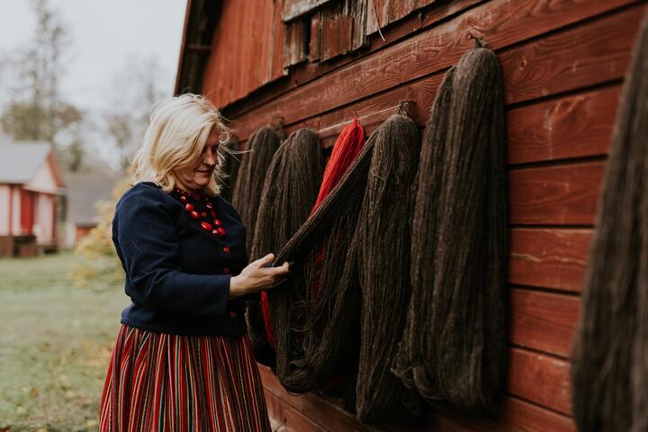 A Kihnu woman checks wool bundles