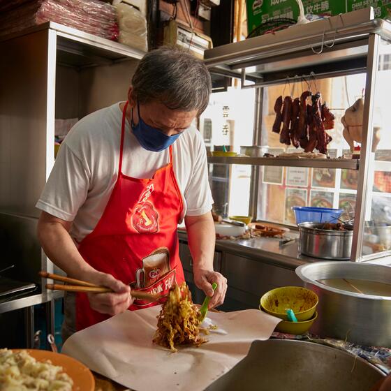 A man prepares food at a Kuala Lumpur breakfast spot