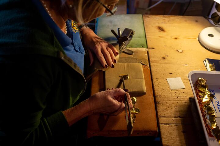 A craftsperson works with gold leaf in venice