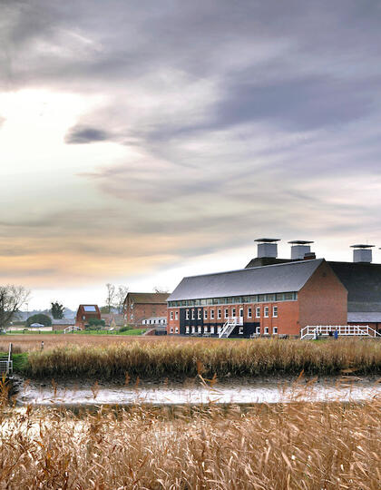 Snape Maltings concert hall as viewed from across the River Alde