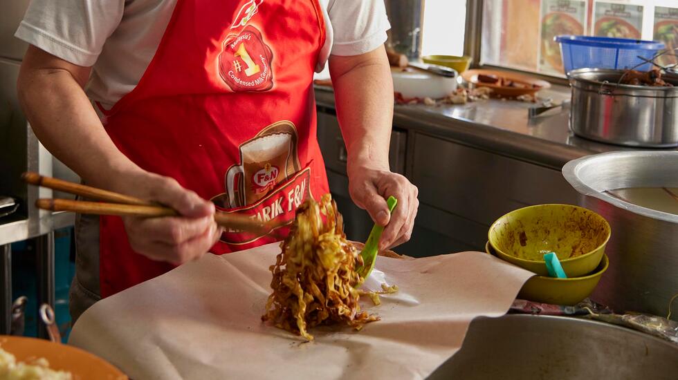 A man prepares food at a Kuala Lumpur breakfast spot