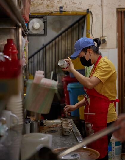 A member of kitchen staff makes coffee