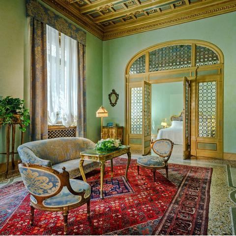 The opulent, green interiors of a suite at Hotel Locarno in Rome, Italy